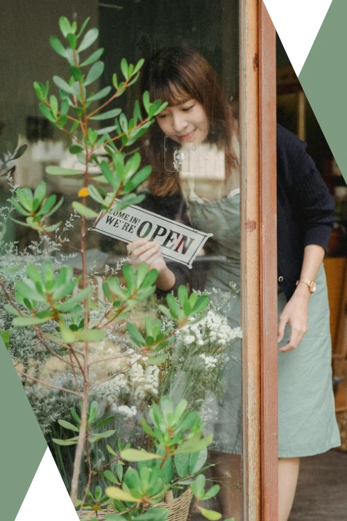 photo of a woman opening her florist shop for the day (featured image: "About Us" section of the About Caesura Strategy page)