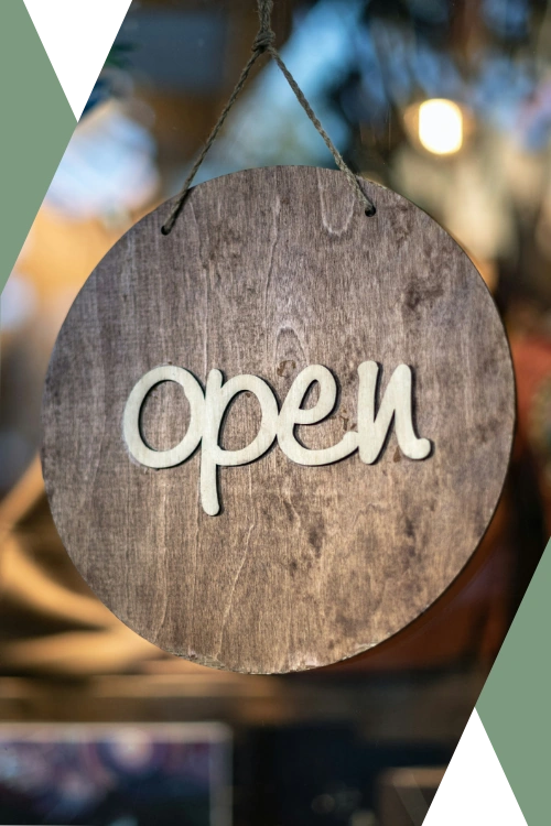photo of a rustic wooden open sign hanging in front of a small business's window ("Why Small and Mid-Size Businesses?" section supporting image on "About Caesura Strategy" page)