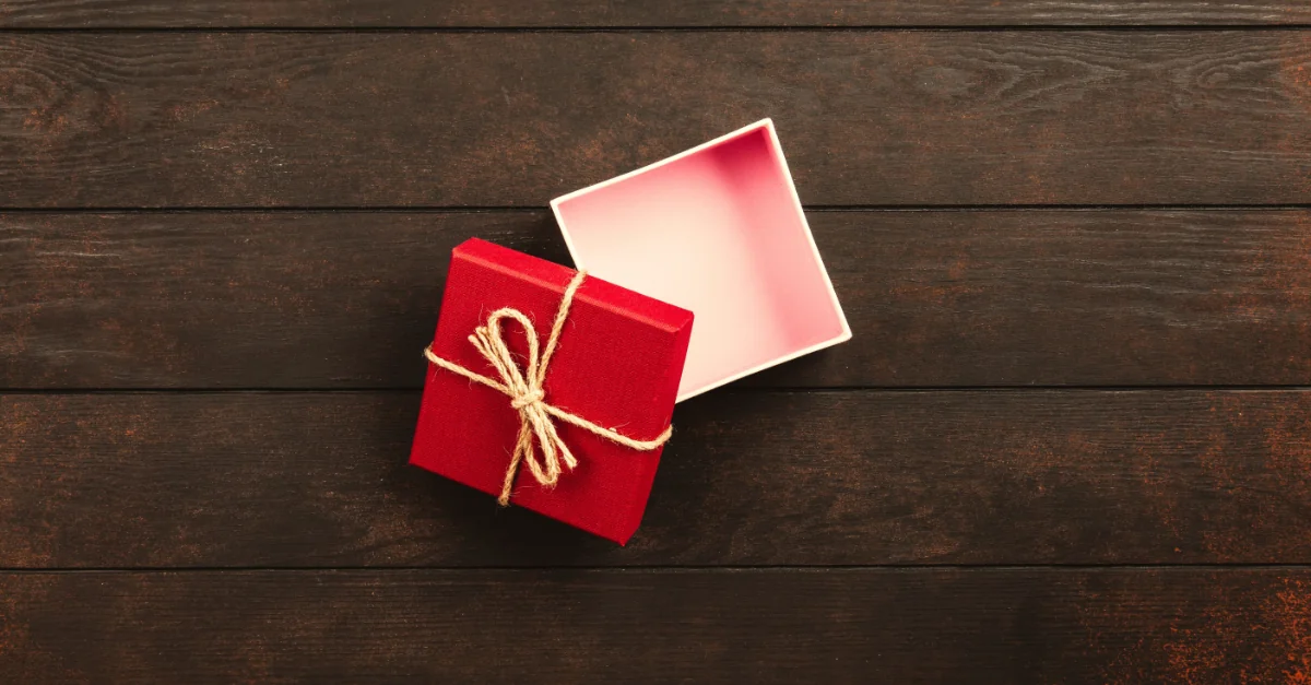 photo of a small, square, empty gift box on a wooden table: the red lid leans against the empty white bottom, wrapped with a twine bow (featured image: "Marketing Is Driving Leads, But Is Your Business Ready?" article)